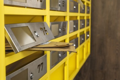Metal mailboxes with keyholes, numbers and envelopes in post office, closeup