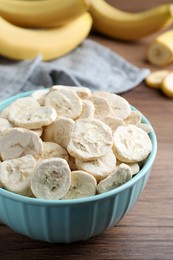 Freeze dried and fresh bananas on wooden table, closeup