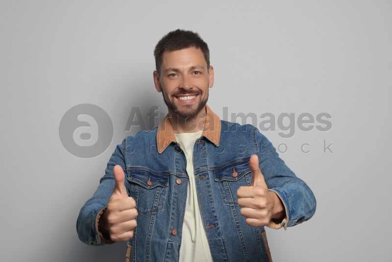 Man showing thumbs up on grey background