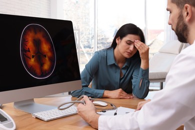 Neurologist consulting young patient at table in clinic