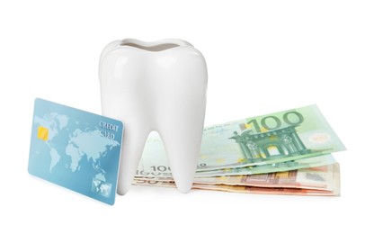 Ceramic model of tooth, euro banknotes and credit card on white background. Expensive treatment