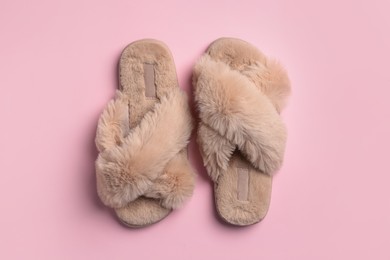 Pair of soft fluffy slippers on pink background, top view