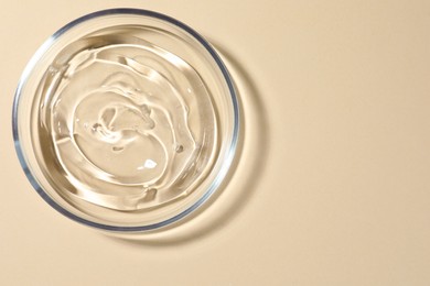 Photo of Petri dish with liquid on beige background, top view. Space for text