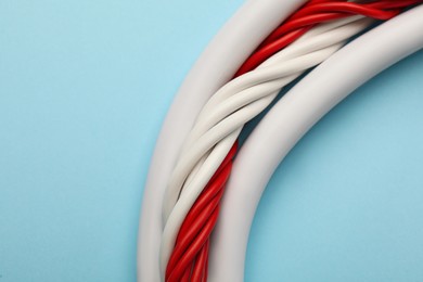 Many electrical cables on light blue background, closeup