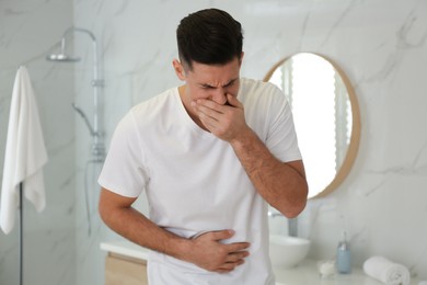 Man suffering from nausea in bathroom. Food poisoning