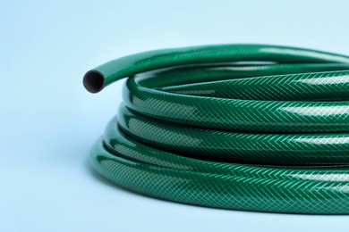 Watering hose on light blue background, closeup