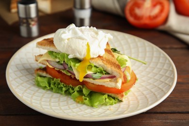 Tasty sandwich with poached egg on wooden table