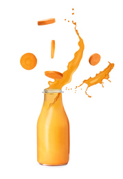 Carrot slices and glass bottle of fresh juice with splashes on white background