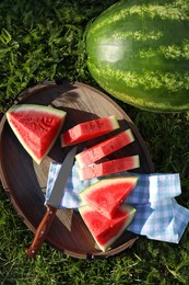 Tasty ripe watermelons on green grass outdoors, flat lay