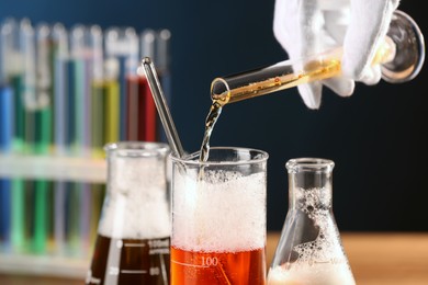 Photo of Scientist working with laboratory glassware indoors, closeup. Chemical reaction