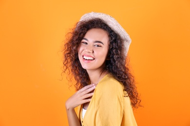 Portrait of laughing African-American woman on color background