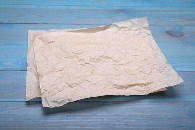 Photo of Sheets of baking paper on light blue wooden table