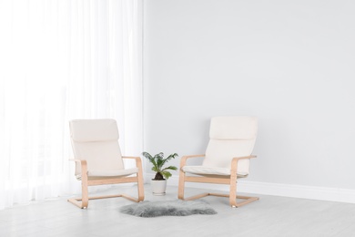 Photo of Elegant room interior with stylish comfortable armchairs