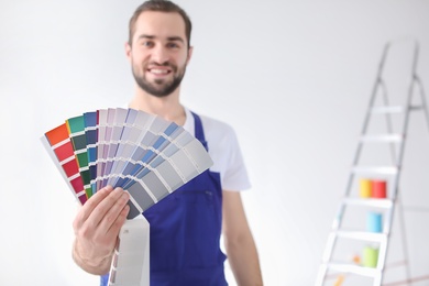 Male decorator with color palette on white background