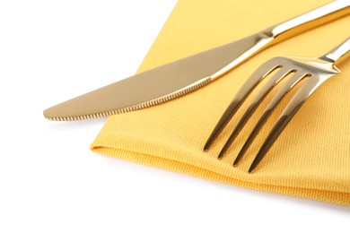 Photo of Yellow napkin with golden fork and knife on white background, closeup