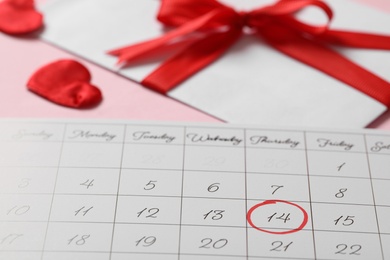 Calendar with marked Valentine's Day on pink background, closeup