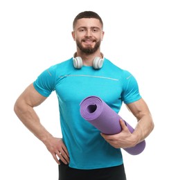 Photo of Handsome man with fitness mat and headphones on white background
