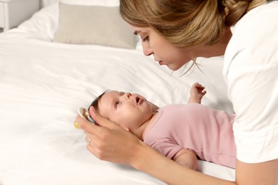 Photo of Mother calming crying daughter on bed indoors