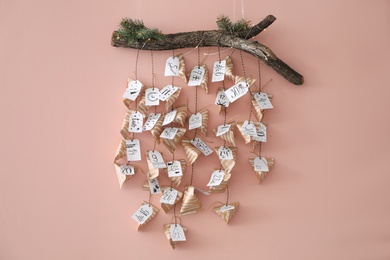 Christmas advent calendar with small gifts hanging on pink wall