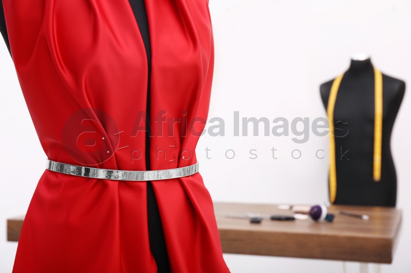 Photo of Mannequin with red cloth in tailor studio