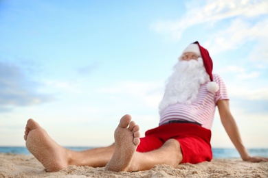 Santa Claus relaxing on beach, space for text. Christmas vacation