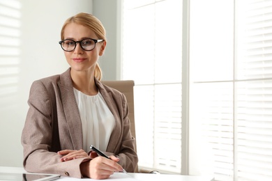 Young businesswoman sitting at table in office