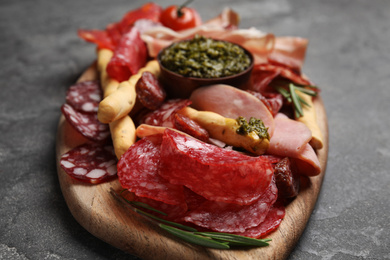 Photo of Tasty ham and other delicacies served on grey table, closeup