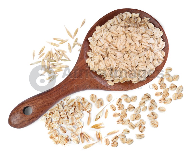 Uncooked oatmeal and wooden spoon on white background, top view