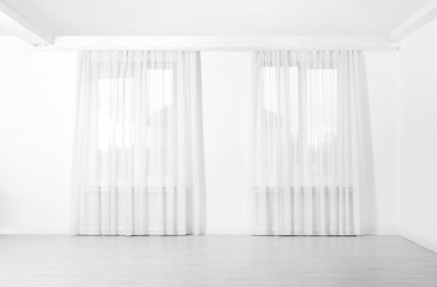 Windows with elegant curtains in empty room