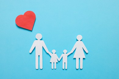 Paper family figures and red heart on light blue background, flat lay. Insurance concept
