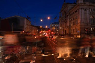 People crossing city street at night, long exposure effect