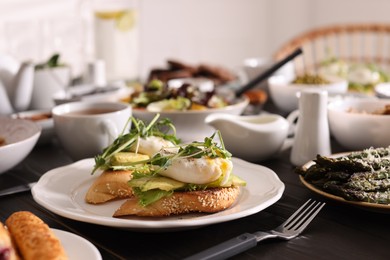 Delicious sandwiches with eggs and avocado served on buffet table for brunch