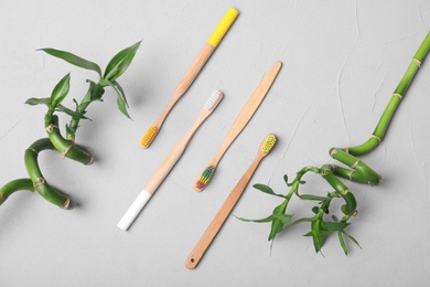 Flat lay composition with bamboo toothbrushes on grey background
