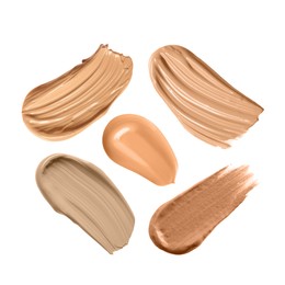 Set with different shades of liquid skin foundation on white background, top view 
