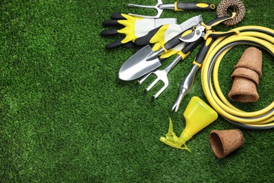 Photo of Flat lay composition with gardening tools on green grass, space for text