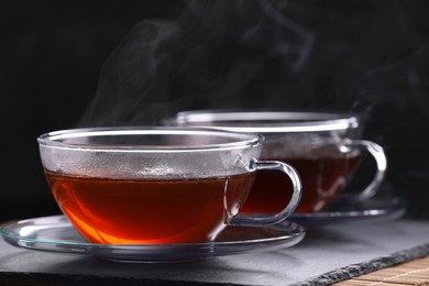 Photo of Aromatic hot tea in glass cups on table, closeup