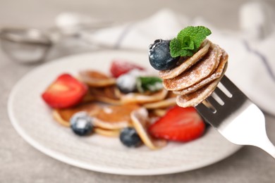 Fork with cereal pancakes, blueberry and mint on blurred background, closeup. Space for text