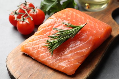 Photo of Fresh raw salmon and ingredients for marinade on grey table, closeup