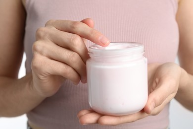 Woman holding jar of hand cream, closeup