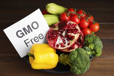 Tasty fresh GMO free products and paper card on wooden table