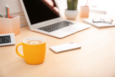 Yellow cup with coffee on office table. Space for text