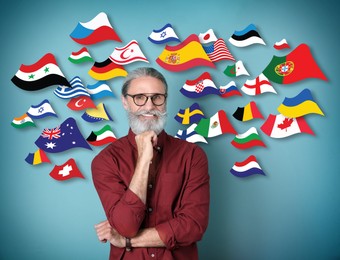 Portrait of mature interpreter and flags of different countries on blue background