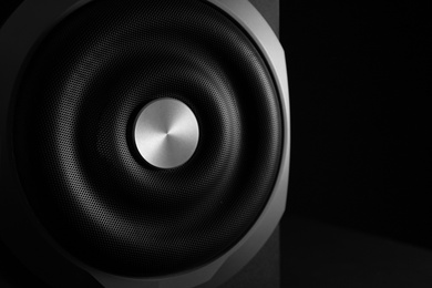 Closeup view of modern subwoofer on black background, space for text. Powerful audio speaker