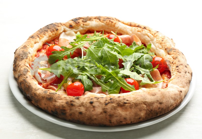 Photo of Tasty pizza with meat and arugula on white table, closeup