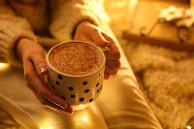Photo of Woman with cup of hot drink at home, closeup. Christmas celebration