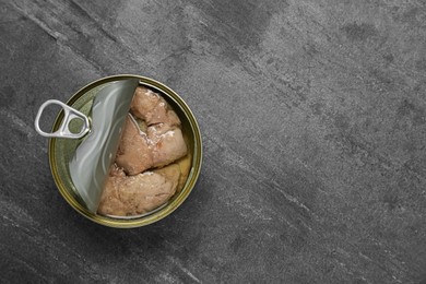 Photo of Open tin can of tasty cod liver on black table, top view. Space for text