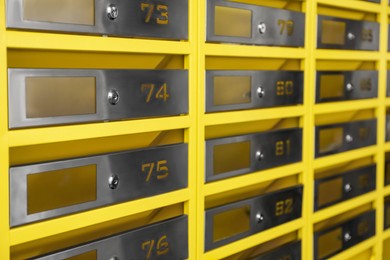 Many closed metal mailboxes with keyholes and numbers as background, closeup