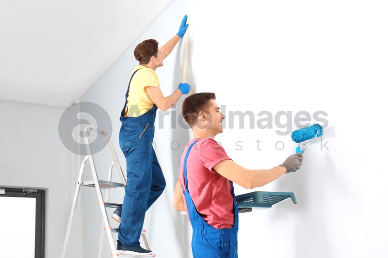 Male decorators refurbishing empty room