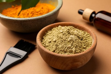 Photo of Bottle, henna and turmeric powder on coral background, closeup. Natural hair coloring