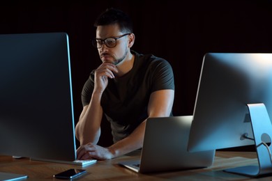 Programmer working in modern office at night